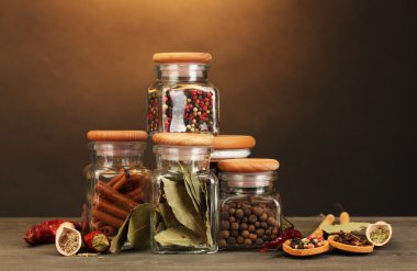 Kavanozlar ve baharatlar kahverengi zemin üzerine ahşap masa üstünde kaşık