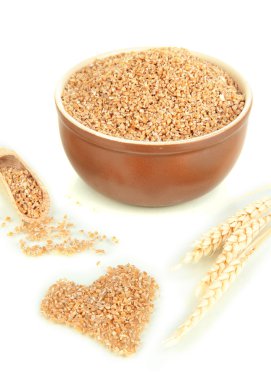 kahverengi kase üzerinde beyaz izole buğday kepeği dolu