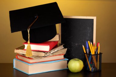 kitap ve magister kap Sarı zemin üzerine ahşap masa üzerine okul yönetimi karşı