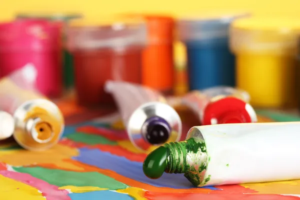 Tubes avec aquarelle colorée et pots avec gouache sur image colorée close-up — Photo
