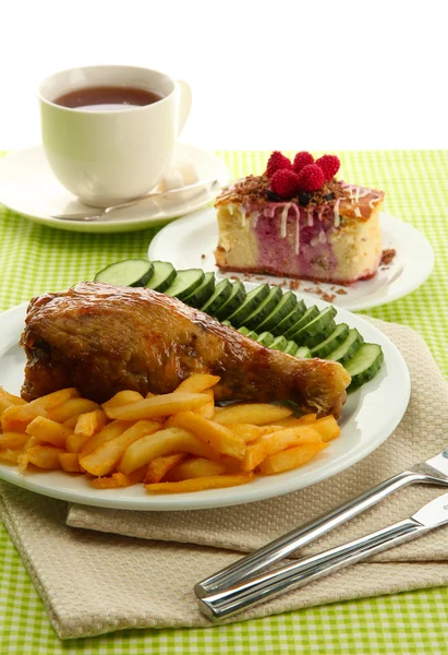 Frango assado com batatas fritas e legumes, xícara de chá e sobremesa, em toalha de mesa verde — Fotografia de Stock