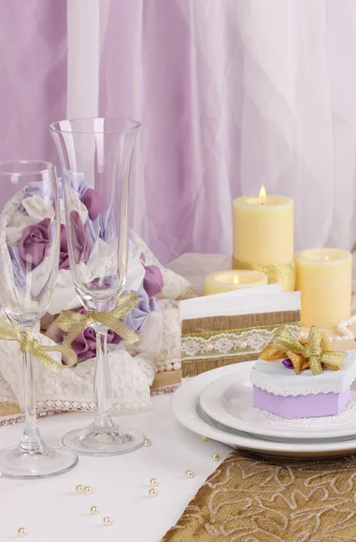 在紫色和金色的颜色，白色和紫色面料背景上服役神话般的婚礼表 — 图库照片