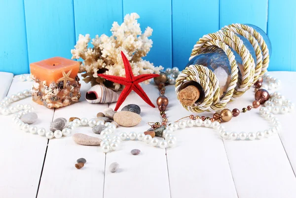 Inrichting van schelpen op houten tafel op blauwe houten achtergrond — Stockfoto