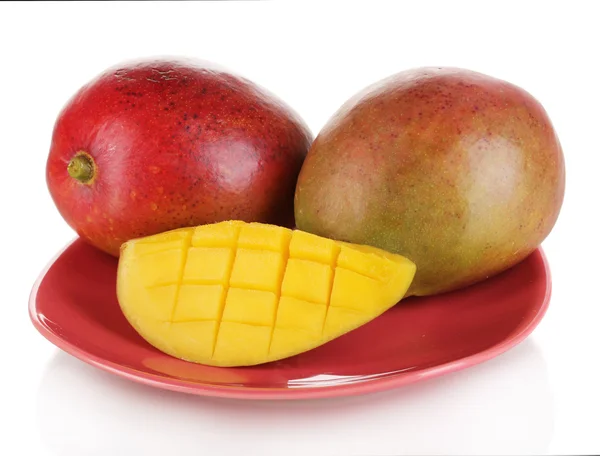 Reife appetitliche Mango auf rotem Teller isoliert auf weißem — Stockfoto