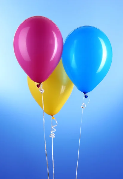 Tres globos de colores sobre fondo azul — Foto de Stock