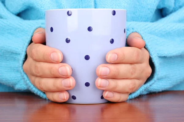 Yakın çekim sıcak bir fincan tutan eller iç — Stok fotoğraf