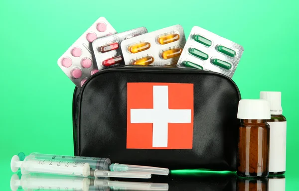 Bolsa de primeros auxilios, sobre fondo verde — Foto de Stock