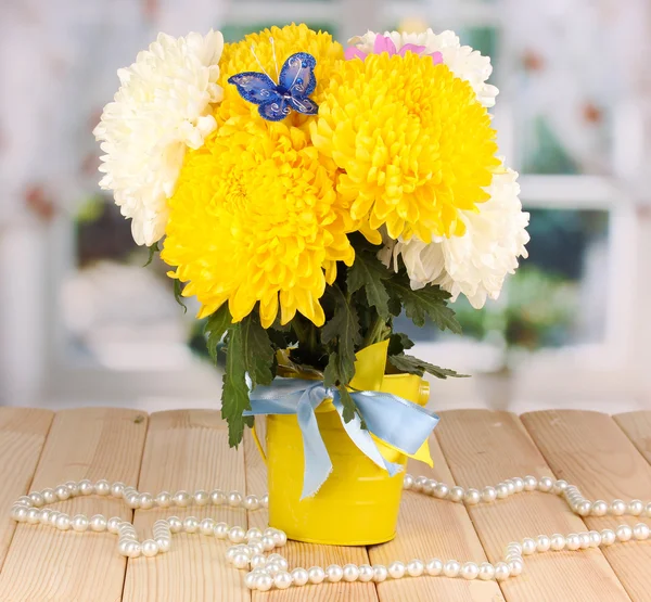 Beautiful chrysanthemum in pail on wooden table on window background — Stock Photo, Image