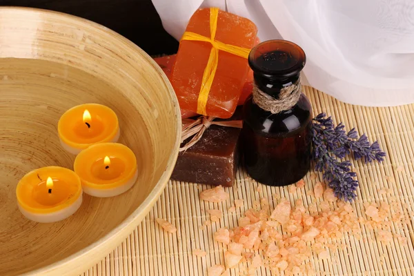 Bottle with aromatic oils with accessories for relaxation close-up on wooden table on wooden background — Stock Photo, Image