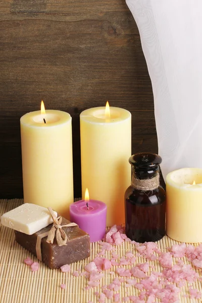 Flasche mit aromatischen Ölen mit Zubehör zur Entspannung aus nächster Nähe auf Holztisch auf Holzhintergrund — Stockfoto