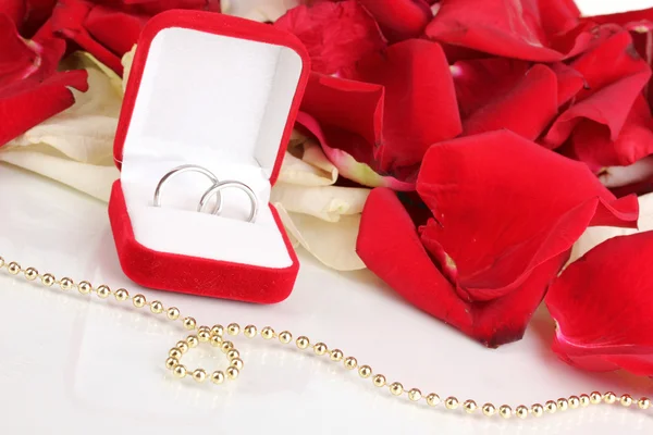 Hermosa caja con anillos de boda en rojo, blanco y rosa pétalos de fondo aislado en blanco —  Fotos de Stock