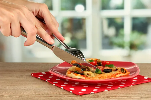 Woman's hands cut a slice of pizza close-up — Stock Photo, Image