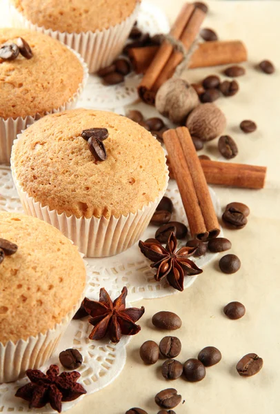 Sabrosos pasteles de magdalenas sobre arpillera, especias y semillas de café, sobre fondo beige —  Fotos de Stock