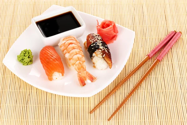 Délicieux sushi servi sur assiette sur tapis de bambou — Photo