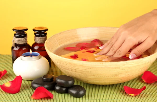 Tratamientos de spa para manos femeninas, sobre fondo amarillo —  Fotos de Stock