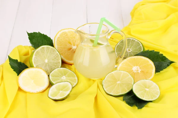 Citrus limonade in glas werper van citrus rond op gele stof op witte houten tafel close-up — Stockfoto