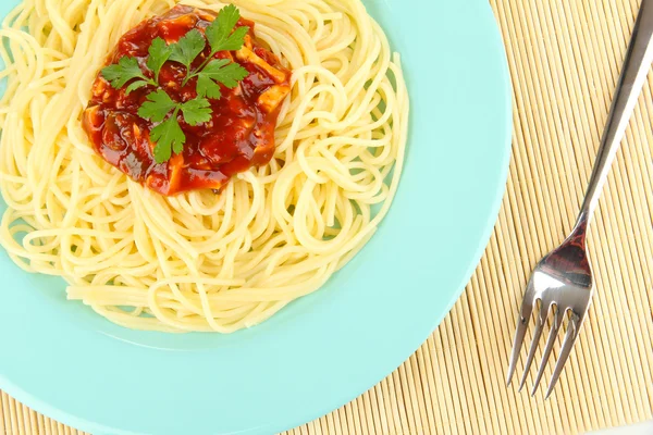 Spaghetti italiani in piatto su tappetino di bambù — Foto Stock