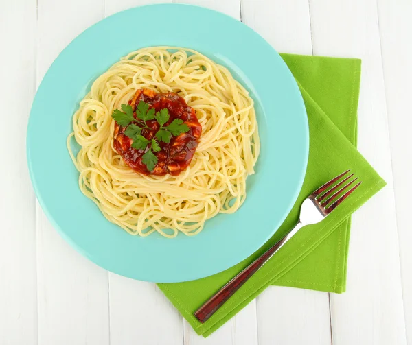 Italské špagety v talíři na dřevěném stole — Stock fotografie