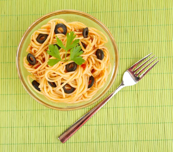 Spaghetti italiani in piatto su tappetino di bambù — Foto Stock