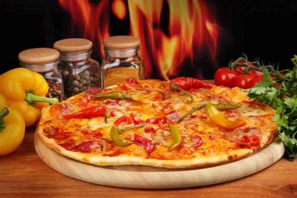 Sabrosa pizza de pepperoni con verduras sobre tabla de madera sobre fondo de llama — Foto de Stock
