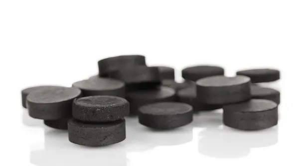 Activated carbon in tablets isolated on white — Stock Photo, Image