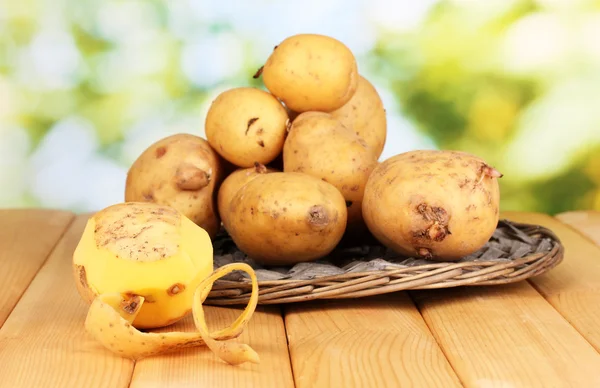 Mogen potatis på wicker vagga på träbord på naturliga bakgrund — Stockfoto