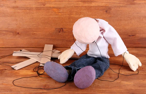 Wooden puppet sitting on wooden background — Stock Photo, Image