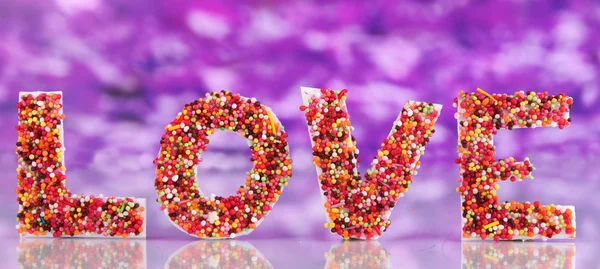 Wort Liebe auf violettem Hintergrund — Stockfoto