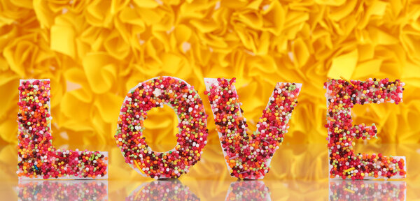 Слово Любовь на декоративном желтом фоне
