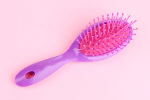 Cepillo de pelo púrpura sobre fondo rosa —  Fotos de Stock