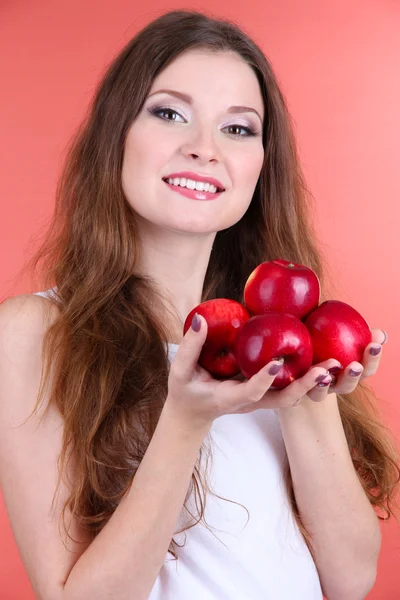 Bella donna con mele su sfondo rosa — Foto Stock