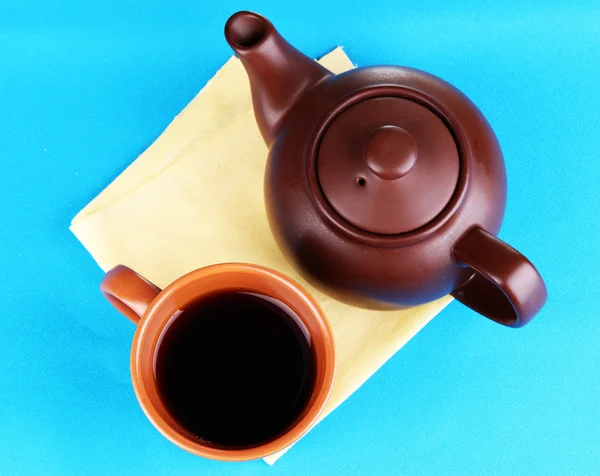 Top view of cup of tea and teapot on blue tablecloths — Stock Photo, Image