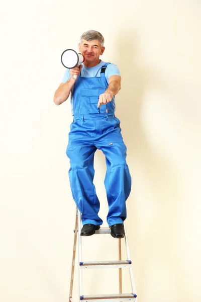Bouw superintendent regisseert reparatie zittend op de ladder — Stockfoto