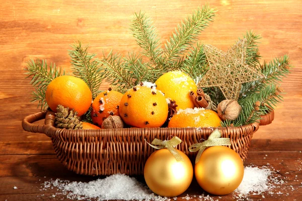 Kerstmis samenstelling in de mand met sinaasappels en fir tree, op houten achtergrond — Stockfoto