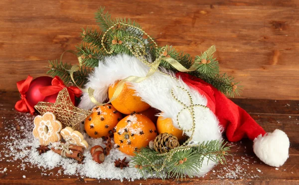 Weihnachtskomposition mit Orangen und Tanne im Weihnachtsmann-Hut — Stockfoto