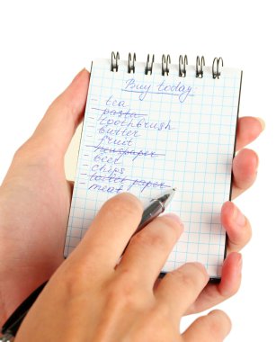 Kadının elinde alışveriş listesi olan bir defter var.