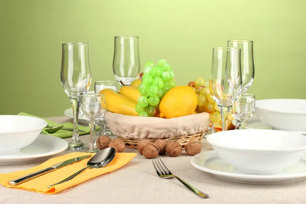 Table setting in green and yellow tones on color background — Stock Photo, Image