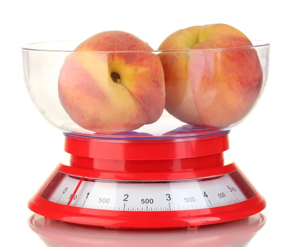 Спелые персики в кухонных весах изолированы на белом — стоковое фото