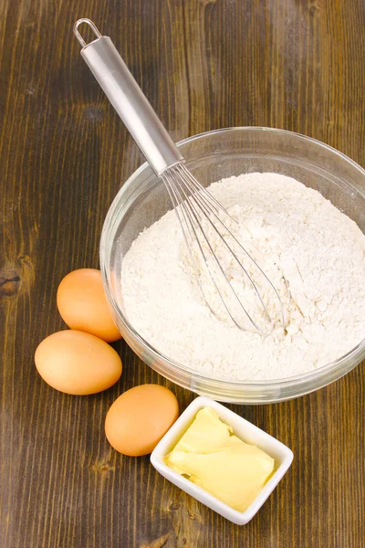 Huevos, harina y mantequilla de cerca en la mesa de madera —  Fotos de Stock