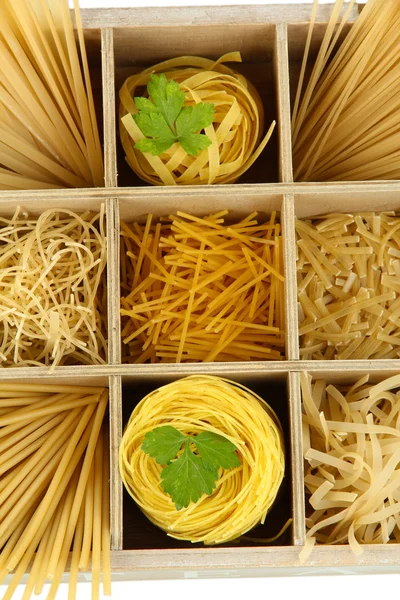 Nine types of pasta in wooden box sections close-up isolated on white — Stock Photo, Image