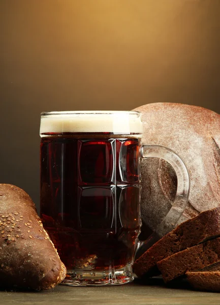 Tankard de pães de kvass e centeio, sobre mesa de madeira sobre fundo marrom — Fotografia de Stock