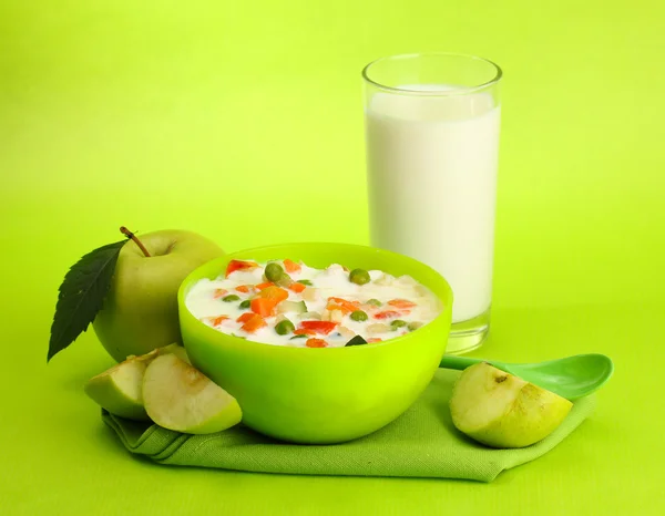 Sabrosos alimentos dietéticos y vaso de leche, sobre fondo verde —  Fotos de Stock