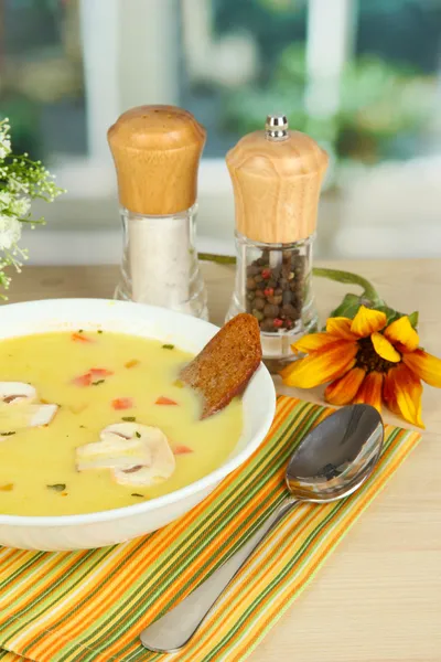 Ароматный суп в белой тарелке на столе на фоне окна крупным планом — стоковое фото