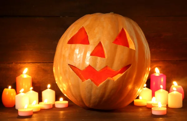 Zucca di Halloween e candele, su sfondo di legno — Foto Stock