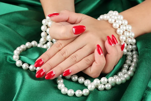 Female hands holding beads on color background — Stock Photo, Image