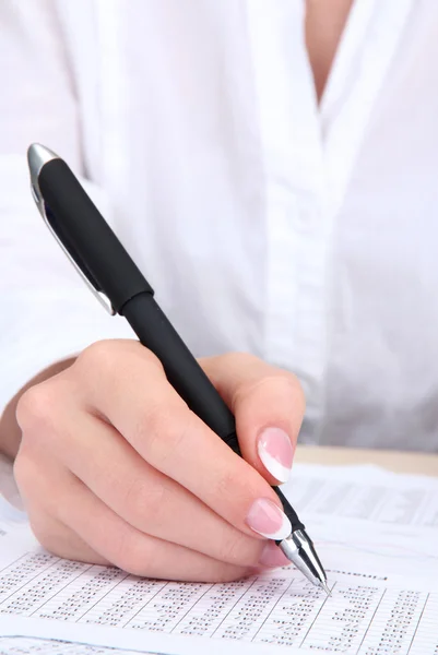 Primer plano de la mano de mujer de negocios, escritura en papel — Foto de Stock