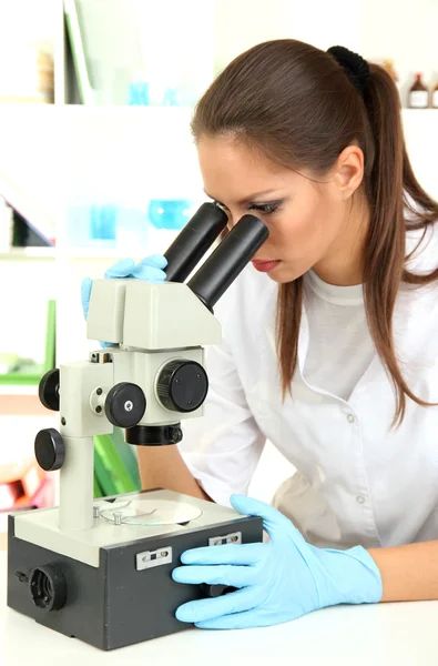 Jovem cientista olhando para o microscópio em laboratório — Fotografia de Stock