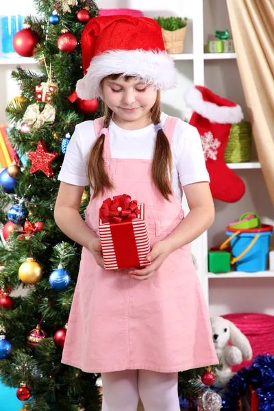 Niña feliz con juguetes de Navidad en la habitación festivamente decorada —  Fotos de Stock