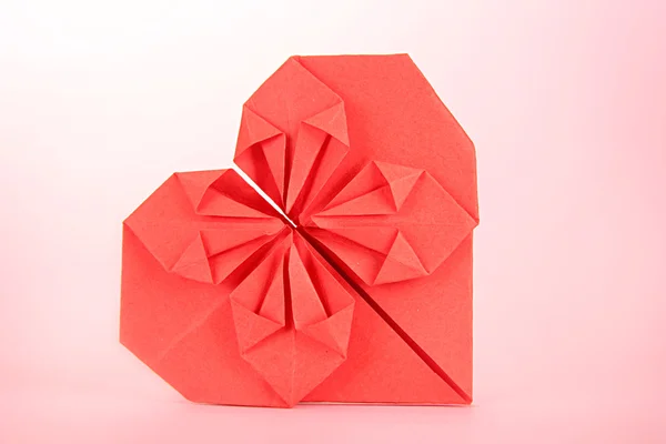 Origami corazón de papel sobre fondo rosa —  Fotos de Stock