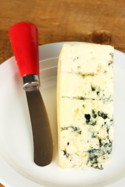 kalıp plakası ve ahşap arka plan yakın çekim üzerinde bıçak ile peynir